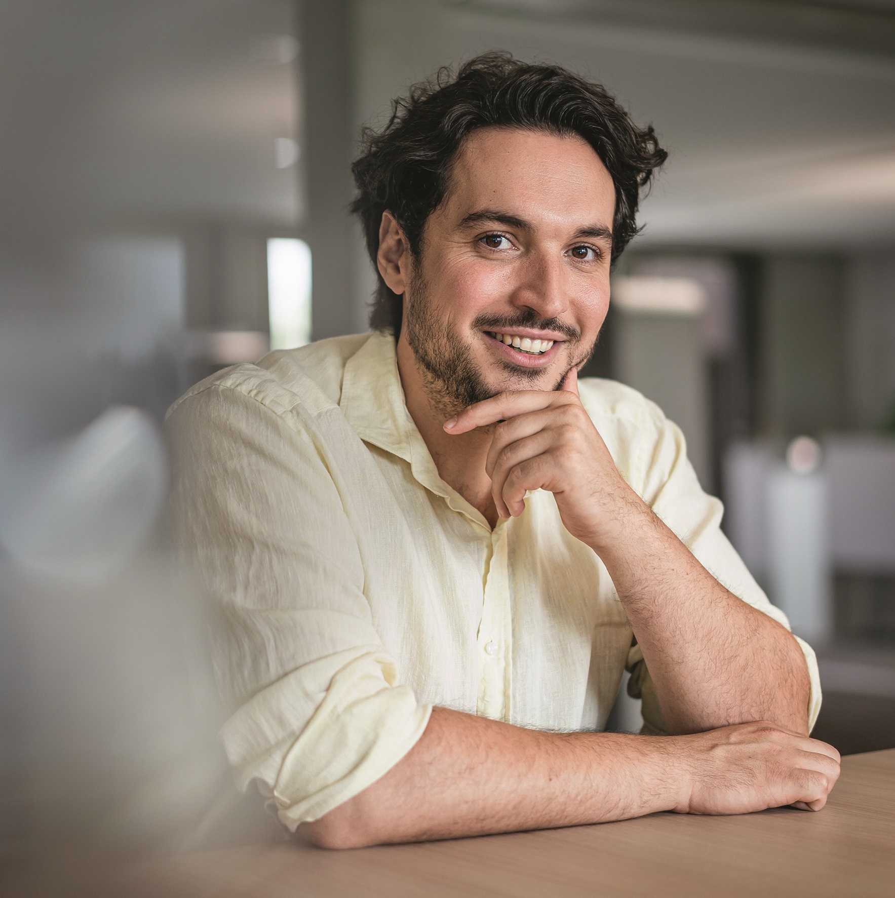 Lächelnder Mann stützt Kinn auf Hand