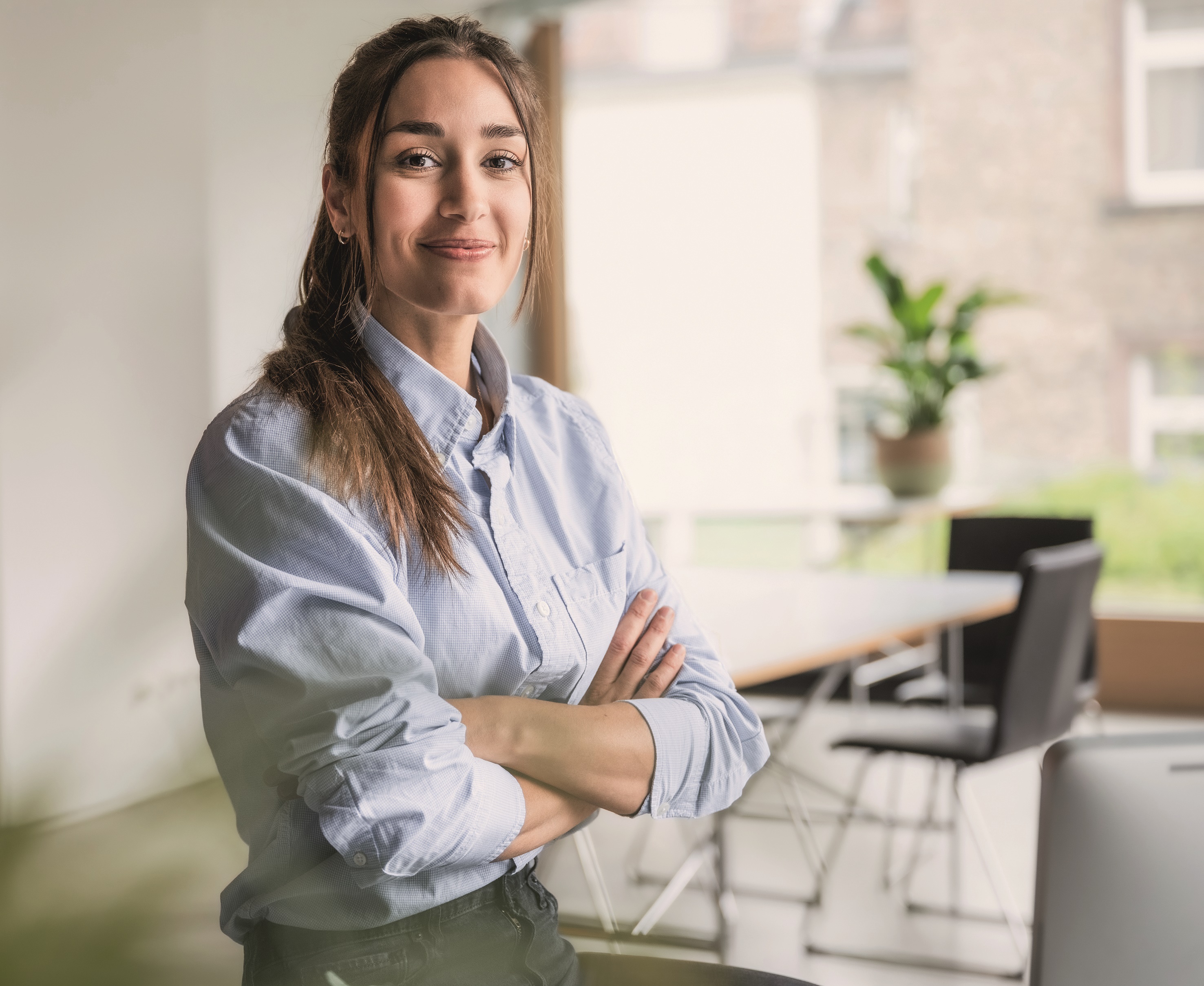 Lächelnde junge Frau mit verschränkten Armen
